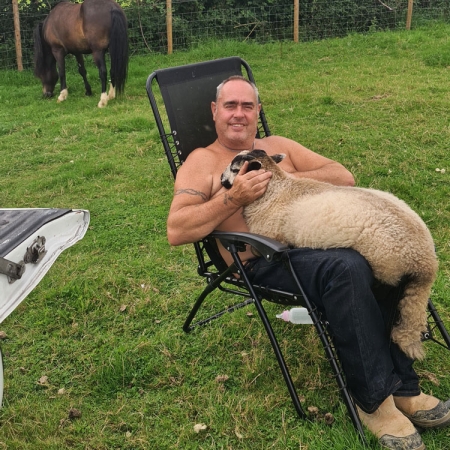 Kane having a seat with a sheep